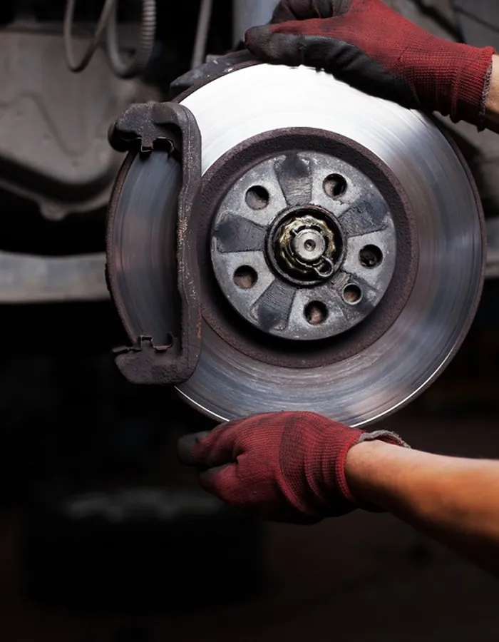 Worn brake rotor and caliper before replacement